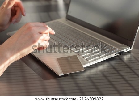 Online shopping concept. Woman hands closeup with laptop and credit card. Woman entering payment information in computer from bank card. High quality photo