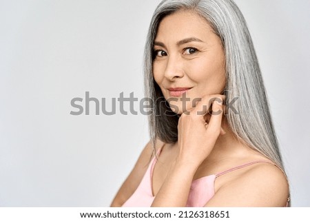 Portrait of gorgeous happy middle aged mature cheerful asian woman, senior older 50s lady pampering her face eyes closed isolated on white. Ads of lifting anti wrinkle skin care, spa. Copy space. Royalty-Free Stock Photo #2126318651