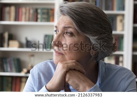 Head shot thoughtful middle aged woman looking in distance, having nostalgic mood, resting in modern home office. Frustrated old business lady stuck with difficult tasks, considering problem solution. Royalty-Free Stock Photo #2126337983