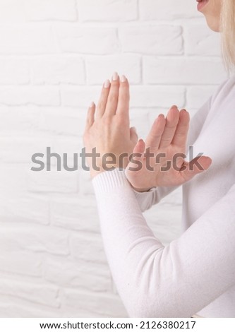 Break the bias symbol of woman's international day. The arms of a girl in white are crossed on a white brick wall. Woman arms crossed to show solidarity, breaking stereotypes, inequality Royalty-Free Stock Photo #2126380217