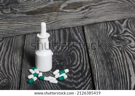 Vial with nasal vaccine and pills. Medicines for coronavirus. Shot close-up.