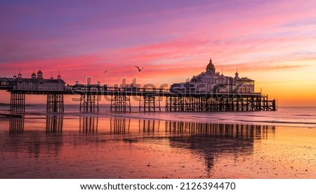 Colourful February sunrise at low tide Eastbourne Pier East Sussex south east England Royalty-Free Stock Photo #2126394470