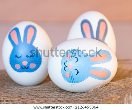 Easter eggs with a bunny pattern. Drawing with paints on a white egg