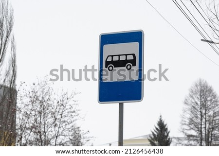 A road sign indicating a bus stop. A road sign installed near the bus stop, against the sky.