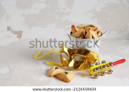 Jewish holiday Purim concept with hamantaschen cookies or haman's ears, carnival mask, noisemaker. 