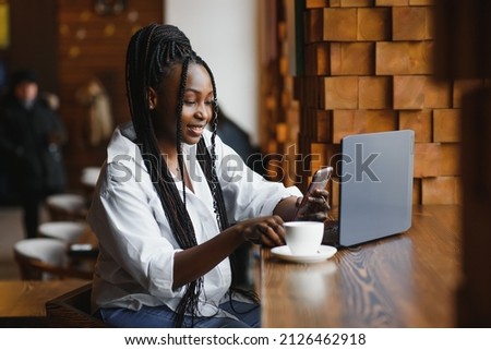 Happy african american woman worker using laptop work study at computer in loft office or cafe, smiling mixed race female student freelancer using pc app dating communicating online watching webinar