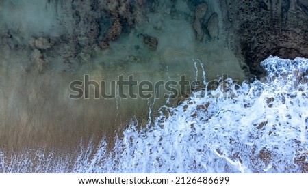 Foamy sea water over volcanic rock off the coast of Maui, Hawaii. Aerial view of Volcanic ash in the ocean.