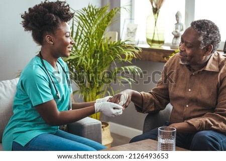 Male patient holding hands with a nurse. Nurse holding hand of senior man in rest home. Doctor helping old patient with Alzheimer's disease. Shot of a caregiver helping a senior man. 