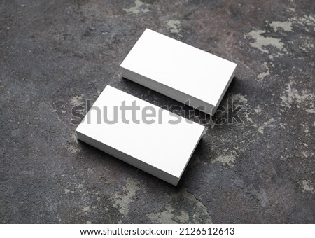 Blank white business cards on concrete background. Mockup for branding identity.