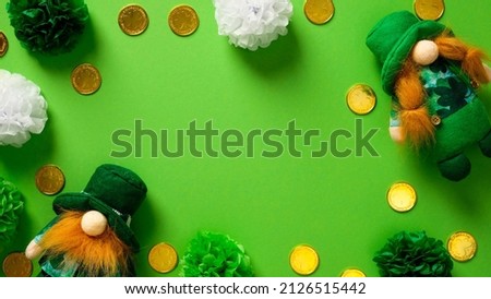 St Patricks day banner design. Flat lay composition with leprechauns, gold coins, holiday decorations on green background, top view. Saint Patrick day poster template.