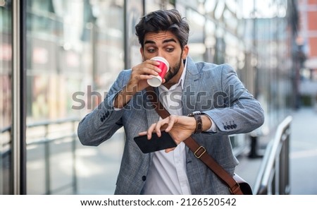 Never don't be late on business meeting. Worried businessman looking at his watch on the way to office. Business, lifestyle concept Royalty-Free Stock Photo #2126520542