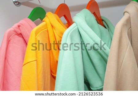 Unisex hooded hoodie set on colorful hangers, unisex modern clothing Royalty-Free Stock Photo #2126523536