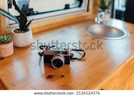 Old analog photo camera on the table of a camper van ready for road trip