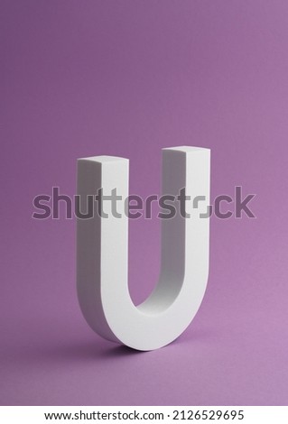Vertical shot of White Letter U on purple color background with copy space