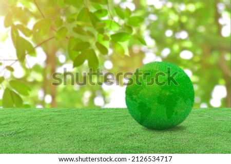 green grass globe earth on meadow over blur nature background. World environment day concept
