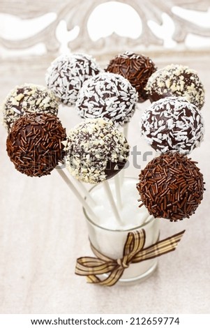Chocolate cake pops isolated on wooden background