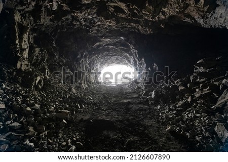 Underground mining, tunnel in the rock. There is a bright light at the end of the tunnel Royalty-Free Stock Photo #2126607890