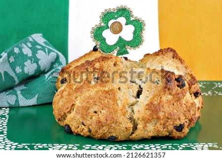 Fresh baked loaf of Irish Soda Bread surrounded by Irish decor. Royalty-Free Stock Photo #2126621357