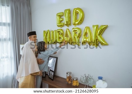 muslim decorating eid mubarak letter made of baloon