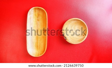 Empty wooden bowl on red background with space for your meal. Food and beverage concept. Food Photography. High angle view. Flat lay. Top view.