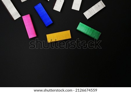 Multicolored paper clips on a black table