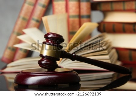Legal Law and Justice concept - Open law book with a wooden judges gavel on table in a courtroom or law enforcement office. Copy space for text