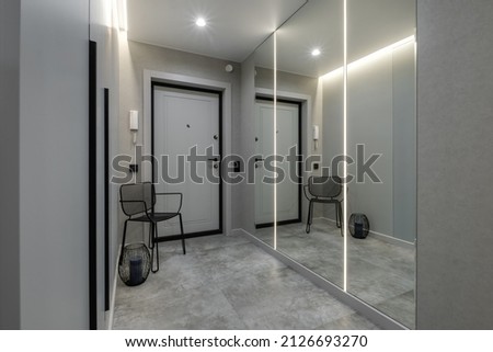 long corridor in interior of entrance hall of modern apartments with doors, cabinets, shelves and a mirror  Royalty-Free Stock Photo #2126693270