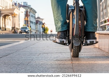 Close-up of the rider's legs on an electric unicycle (EUC). Driving around the city on an electric monowheel. Royalty-Free Stock Photo #2126699612