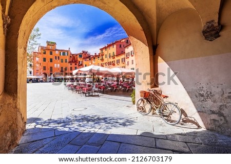 Lucca, Italy - View of Piazza dell'Anfiteatro square through the arch, ancient Roman Empire amphitheater, famous Tuscany. Royalty-Free Stock Photo #2126703179