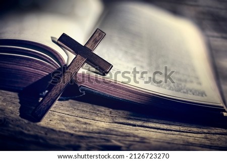 Praying with wooden crucifix cross on Holy Bible study background Royalty-Free Stock Photo #2126723270