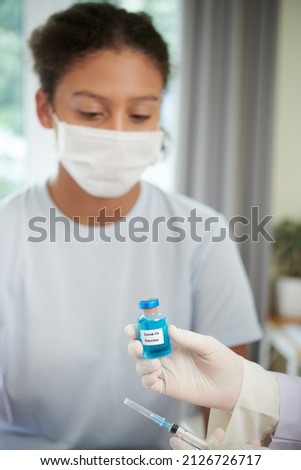 Doctor taking a vaccination to the girl