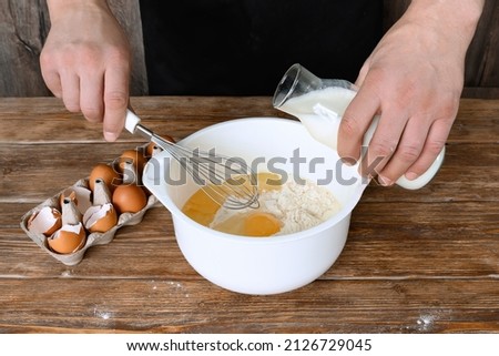 A man prepares dough on rustic wooden table. Close-up