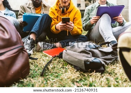 International students sitting together on green campus lawn - Group of high school teens studying outside college - Multiethnic millenial friends doing homework in university park - Academic concept Royalty-Free Stock Photo #2126740931