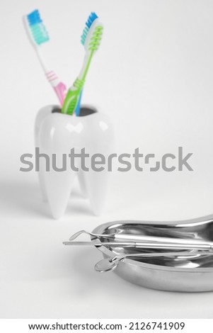 Kidney shaped tray with set of dentist's tools on light background, closeup. Space for text
