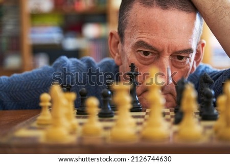 Memory loss prevention concept. Senior man looking at chess board Royalty-Free Stock Photo #2126744630