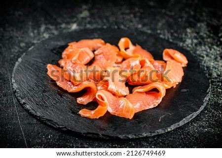 Salted salmon on a stone board. On a black background. High quality photo