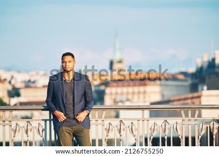 Outdoor portrait of handsome african american man, city landscape on background