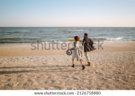 Stylish couple walking and hugging by the sea. Springtime. Relaxation, youth, love, lifestyle solitude with nature. Royalty-Free Stock Photo #2126758880