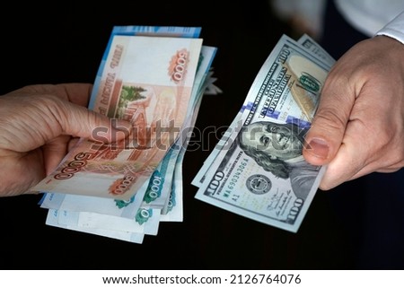 Hands holding russian rouble and us dollar bills. dollars and rubles. concept of currency exchange. Royalty-Free Stock Photo #2126764076