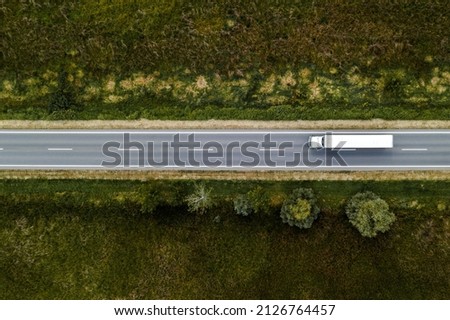 Large freight transporter semi-truck on the road, aerial view top down from drone pov Royalty-Free Stock Photo #2126764457