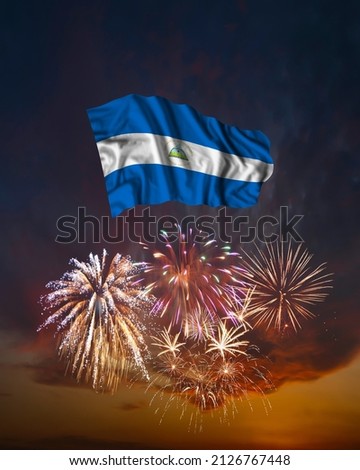 Holiday fireworks in evening sky and flag of Nicaragua for National Independence day