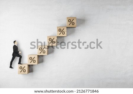 Businessman walking on abstract growing interest rate with arrow on concrete background with mock up place. Investment and finance concept Royalty-Free Stock Photo #2126771846