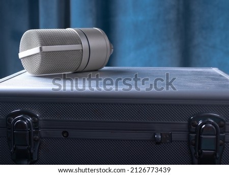 The Condenser Microphone On A Metal Box On A Background Of A Blue Curtain.