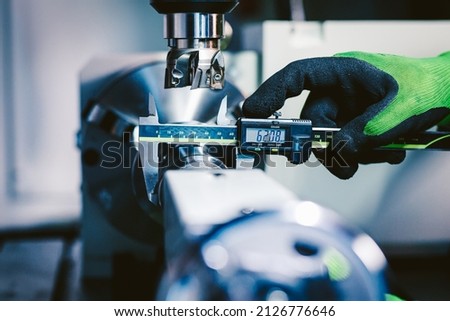 Quality control manufacturing.Hands of an engineer measures a metal part with a digital vernier caliper Royalty-Free Stock Photo #2126776646