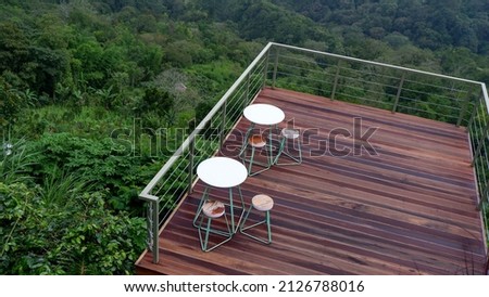 Cafe exterior with wooden decking, is a floor covering material made of wood which is generally used for out door areas that are often exposed to rain and sun. Royalty-Free Stock Photo #2126788016