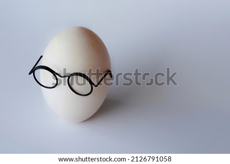 White shell egg wear glasses on white background with copy space for text