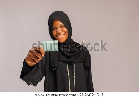 beautiful Muslim young woman with business card in hand