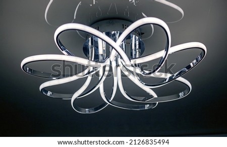 chrome led chandelier hanging on the ceiling in a modern interior. Interior Design Royalty-Free Stock Photo #2126835494