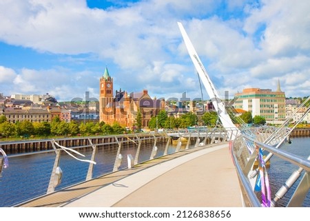 Urban skyline of Derry city (also called Londonderry) in northern Ireland with the famous Peace Bridge (Europe - Northern Ireland). Royalty-Free Stock Photo #2126838656