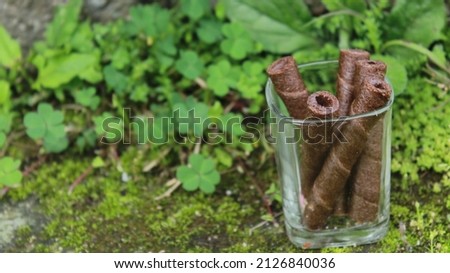 Chocolate wafer stick roll, Crunchy chocolate wafer stick is in a glass, delicious, sweet, snack.